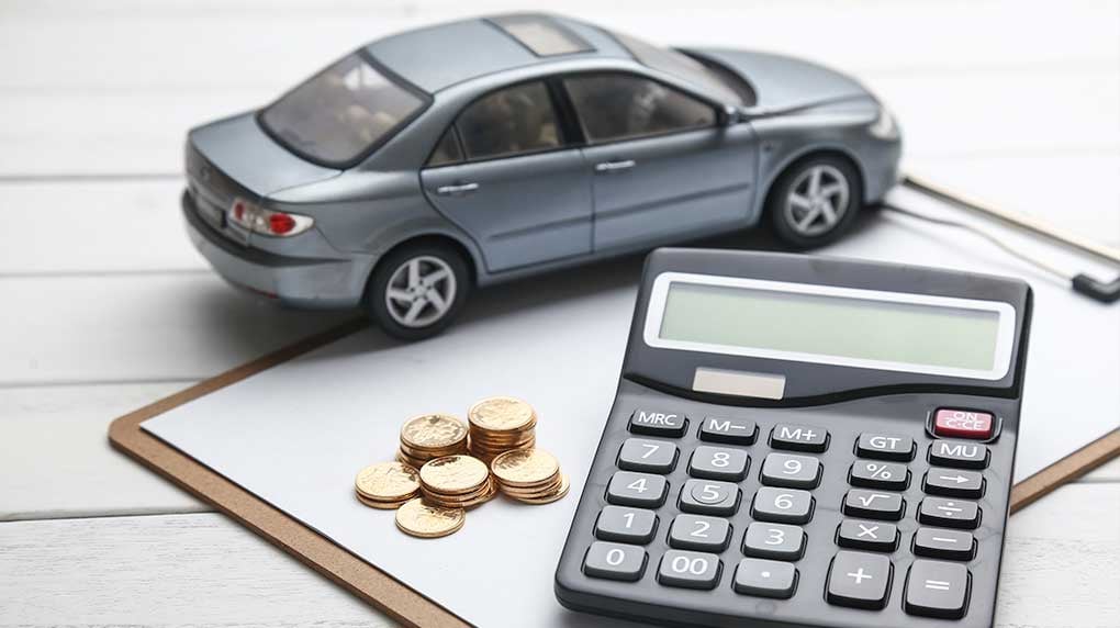 a toy car, clipboard, coins and calculator on a table