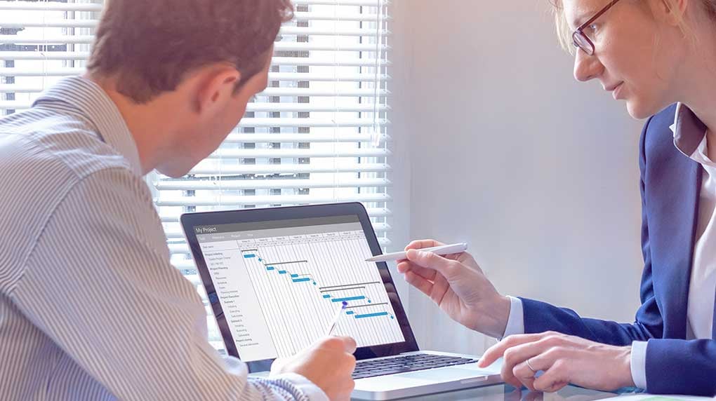 two people looking at a gantt chart on a laptop